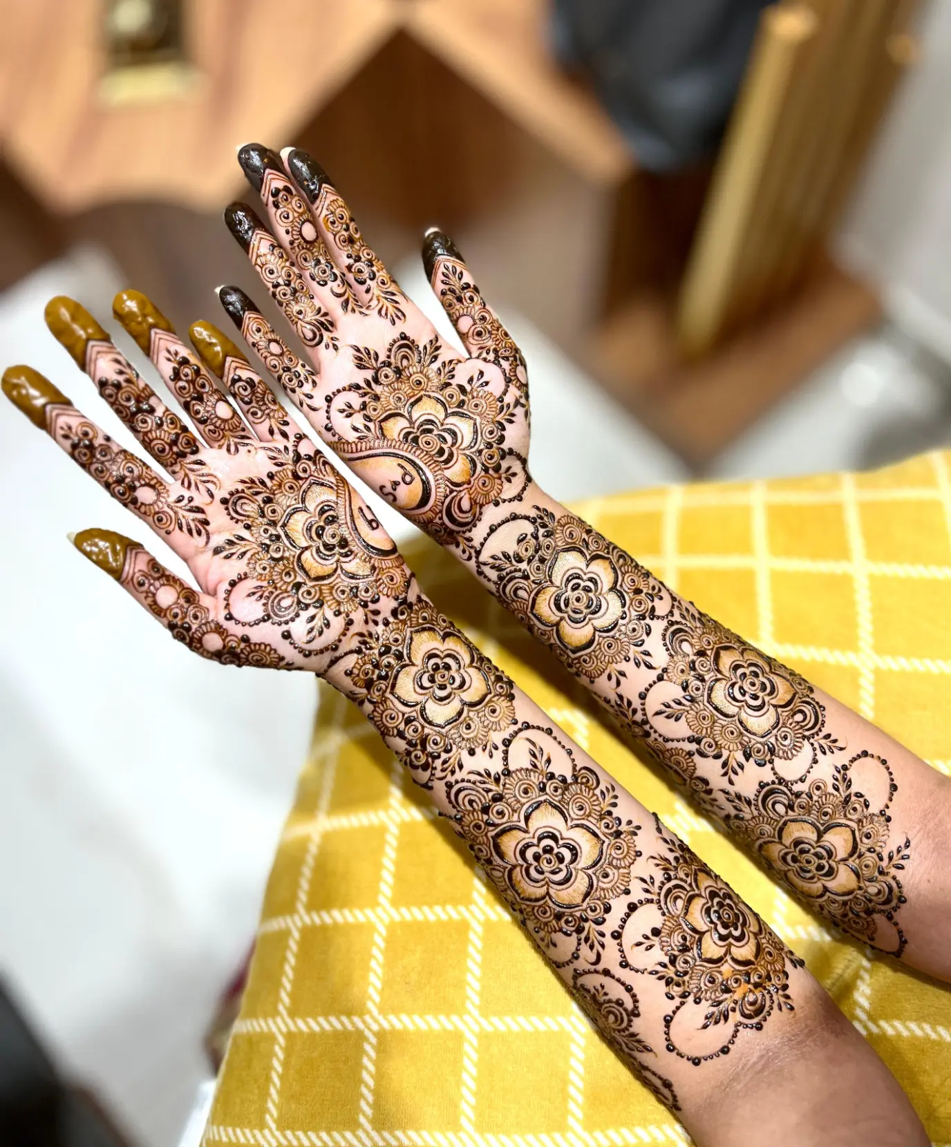 Beautiful floral mehndi design with layered petals, dot detailing, and ornate patterns covering the hands and forearms.