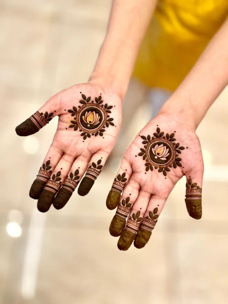 Minimal palm mehndi design featuring a central floral mandala and neat fingertip patterns, captured on a soft beige background